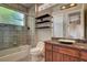 Bathroom featuring a shower-over-tub, granite counters, and floating wood shelves at 205 Red Rock Rd, Boulder City, NV 89005