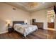 Bedroom with hardwood floors, a ceiling fan, and a view into the ensuite bathroom at 205 Red Rock Rd, Boulder City, NV 89005