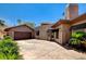 Exterior view of a home with a tile roof, desert landscaping, and a multi-car garage at 205 Red Rock Rd, Boulder City, NV 89005