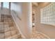Stairway with tile flooring, stainless steel handrail, and natural light from glass block windows at 205 Red Rock Rd, Boulder City, NV 89005