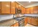 Close-up of kitchen with granite countertops, stainless steel range and microwave, and wood cabinets at 2144 Marywood Park Ct, Henderson, NV 89044