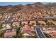 High-angle view of a neighborhood with desert landscaping, tile roofs, and mountain backdrop at 2144 Marywood Park Ct, Henderson, NV 89044