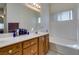 Bright bathroom featuring double sinks, wood cabinets, and a soaking tub at 2200 Valley Heights Ave, Henderson, NV 89052