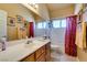 Bright bathroom with a large mirror, warm lighting, and a well-maintained vanity at 2200 Valley Heights Ave, Henderson, NV 89052