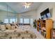 Bright main bedroom with a large mirror, ceiling fan, and modern entertainment setup at 2200 Valley Heights Ave, Henderson, NV 89052