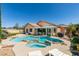 Gorgeous backyard features a sparkling pool and spa with rock accents, surrounded by lush landscaping and patio at 2200 Valley Heights Ave, Henderson, NV 89052