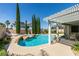 Gorgeous backyard pool with rocks, lounging area, and covered patio at 2200 Valley Heights Ave, Henderson, NV 89052