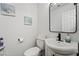 Cozy half-bathroom with modern fixtures, toilet, sink and decorative wall art at 2507 Albemarle Way, Henderson, NV 89014