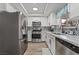 Updated kitchen boasts stainless steel appliances, white cabinets, black hardware, and patterned tile backsplash at 2507 Albemarle Way, Henderson, NV 89014