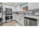 Kitchen with stainless steel appliances, decorative backsplash, and bright white cabinets at 2507 Albemarle Way, Henderson, NV 89014