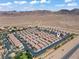 An aerial view of a neighborhood with red tiled roofs nestled at the base of a desert mountain range at 2596 Lazy Saddle Dr, Henderson, NV 89002
