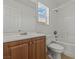 Clean bathroom featuring a shower-tub combo, white tile, a toilet and a wood vanity at 2596 Lazy Saddle Dr, Henderson, NV 89002