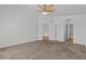 Spacious carpeted bedroom featuring a ceiling fan and doorways to a bathroom and hall at 2596 Lazy Saddle Dr, Henderson, NV 89002
