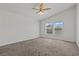 Carpeted bedroom featuring a vaulted ceiling, ceiling fan, and large windows at 2596 Lazy Saddle Dr, Henderson, NV 89002