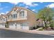 Street view of townhome featuring a 2-car garage, neutral paint, and desert landscaping at 2596 Lazy Saddle Dr, Henderson, NV 89002