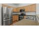 Well-lit kitchen with stainless steel appliances, wooden cabinets and a double basin sink at 2596 Lazy Saddle Dr, Henderson, NV 89002