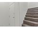 Staircase featuring carpeted stairs, white walls, and access to upper levels at 2596 Lazy Saddle Dr, Henderson, NV 89002