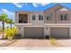 Charming townhome featuring a private balcony and two-car garage, enhanced by lush palm trees and desert landscaping at 295 Callen Falls Ave # 2225, Henderson, NV 89011