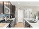 The open kitchen features stainless appliances, stylish backsplash, light countertops, dark cabinets, and counter seating at 295 Callen Falls Ave # 2225, Henderson, NV 89011