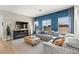 Bright living room with large windows, stylish blue accent wall, plush grey sofa, and modern entertainment center at 295 Callen Falls Ave # 2225, Henderson, NV 89011