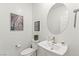 Elegant powder room featuring modern fixtures, a round mirror, and unique wall art at 295 Callen Falls Ave # 2225, Henderson, NV 89011