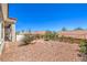 Well-maintained backyard with desert landscaping, privacy fencing, and a glimpse of the covered patio, offering a tranquil retreat at 3028 Treesdale Dr, Las Vegas, NV 89134
