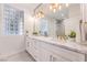 Modern bathroom featuring double sinks, marble countertops, and glass-block window at 3028 Treesdale Dr, Las Vegas, NV 89134