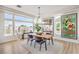 Bright dining area with large windows, modern light fixture, and views of the outdoor landscape at 3028 Treesdale Dr, Las Vegas, NV 89134