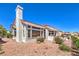 Beautiful home exterior with desert landscaping, large windows, and a built-in grill, showcasing modern design and outdoor living at 3028 Treesdale Dr, Las Vegas, NV 89134