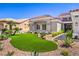 Eye-catching home with artificial turf in the front yard, complemented by attractive desert landscaping at 3028 Treesdale Dr, Las Vegas, NV 89134