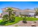 Attractive one-story home boasting a tile roof, three-car garage and desert landscaping with green turf at 3028 Treesdale Dr, Las Vegas, NV 89134