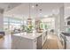 Bright modern kitchen featuring a large waterfall island, stainless appliances, and pendant lighting at 3028 Treesdale Dr, Las Vegas, NV 89134