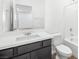 Bright bathroom with a single sink vanity with quartz countertop and a shower-tub combo with a white tile surround at 336 Taylor St, Henderson, NV 89015