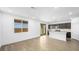 Open-concept living space with wood-look tile flooring, large windows and glass doors, plus a view to the kitchen at 336 Taylor St, Henderson, NV 89015