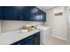 Well-equipped laundry room with blue cabinetry, white countertops, and modern appliances at 338 Taylor St, Henderson, NV 89015