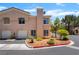 Condo exterior featuring a two-car garage, lush landscaping and a well-maintained exterior at 3950 S Sandhill Rd # 130, Las Vegas, NV 89121