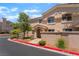 Condo exterior boasts a red-curbed street, mature tree, and inviting front entrance at 3950 S Sandhill Rd # 130, Las Vegas, NV 89121