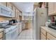 Open-concept kitchen featuring white appliances, tile countertops, and a view of the dining area at 3950 S Sandhill Rd # 130, Las Vegas, NV 89121