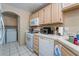 Functional kitchen featuring white appliances and light wood cabinets, with a laundry area visible at 3950 S Sandhill Rd # 130, Las Vegas, NV 89121