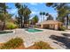 Community pool area with a pool house, lounge chairs and mature trees at 3950 S Sandhill Rd # 130, Las Vegas, NV 89121