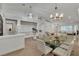 Bright open dining area with modern chandelier, and seamless flow into the living spaces at 4196 Balmoral Castle Ct, Las Vegas, NV 89141