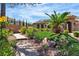Well-maintained front yard, featuring lush landscaping, a stone walkway, and vibrant plants at 4196 Balmoral Castle Ct, Las Vegas, NV 89141
