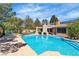 Expansive pool and backyard retreat with covered patio, multiple seating areas, and lush landscaping at 4196 Balmoral Castle Ct, Las Vegas, NV 89141