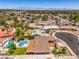 This aerial shot captures a lush community with pools, green landscaping and city views, nestled in a serene setting at 4475 Harmony Ct, Las Vegas, NV 89121