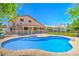 Large backyard showcasing a pool, green lawn, and covered patio for outdoor living and relaxation at 4475 Harmony Ct, Las Vegas, NV 89121