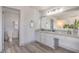 Well-lit bathroom features a double vanity, a large mirror, and an adjacent toilet room at 4475 Harmony Ct, Las Vegas, NV 89121