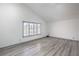 Bright bedroom featuring gray wood-look flooring, neutral walls, and window with shutter style blinds at 4475 Harmony Ct, Las Vegas, NV 89121