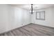 Bright bedroom featuring gray wood-look flooring, neutral walls, and window with shutter style blinds at 4475 Harmony Ct, Las Vegas, NV 89121