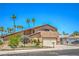 Inviting two-story home features lush landscaping, mature palm trees, and a wide driveway leading to an attached garage at 4475 Harmony Ct, Las Vegas, NV 89121