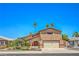 Charming stucco home with a two-car garage, palm trees, and colorful landscaping at 4475 Harmony Ct, Las Vegas, NV 89121